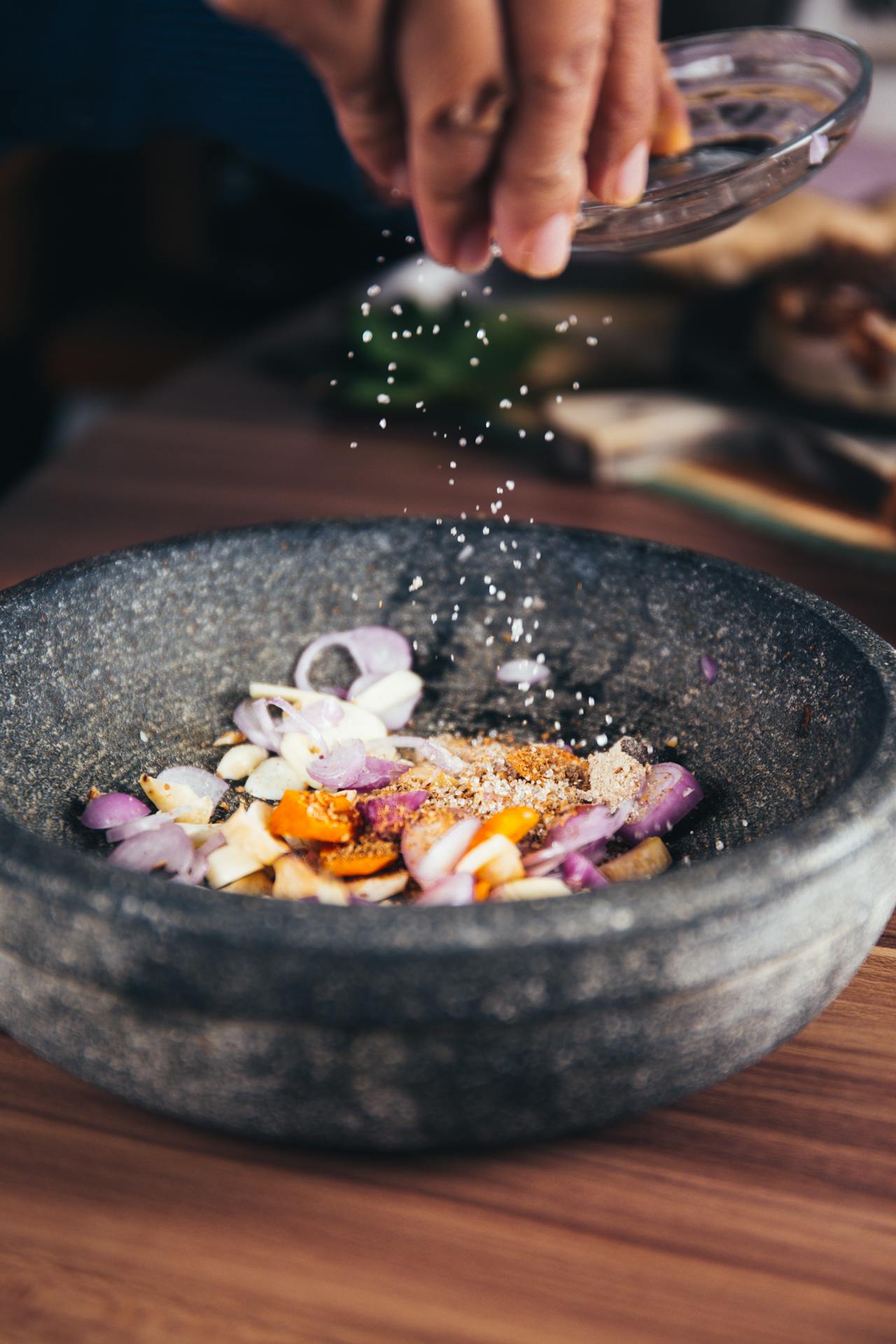 Hand garnishing food with salt.